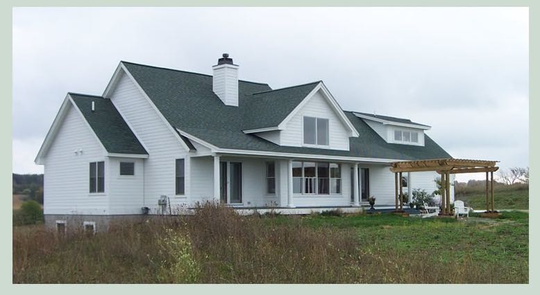 White farmhouse with a wraparound porch