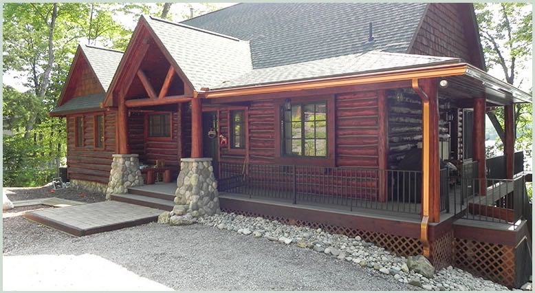 Log home with stone pillars and covered porch