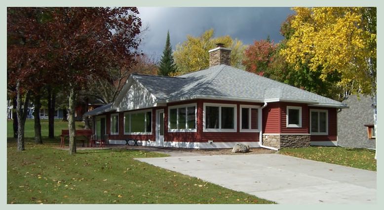 Red ranch home with a stone chimney