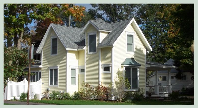 Pale yellow two-story cottage